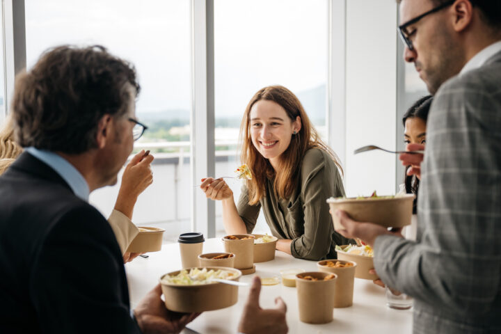 Smiling woman enjoying takeaway lunch at work